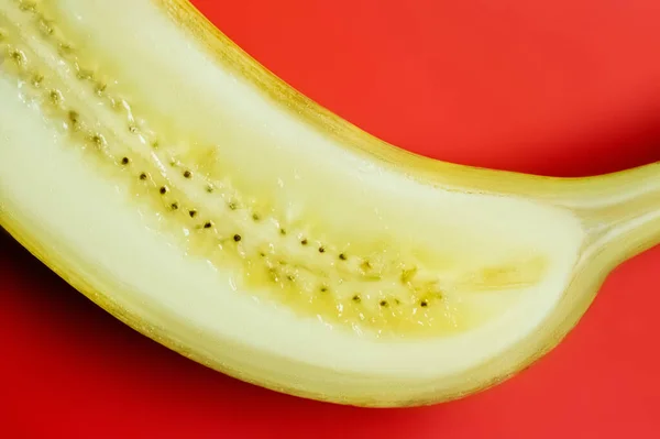 Vista de cerca del plátano cortado sobre fondo rojo - foto de stock