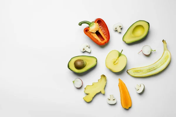 Flat lay with cut fresh fruits and vegetables on white background — Stock Photo