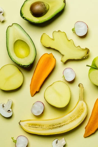 Flat lay with cut fruits and vegetables on yellow background — Stock Photo