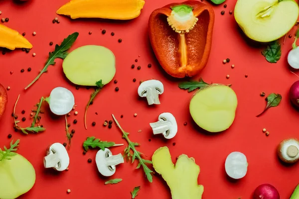 Top view of greenery, peppercorns and fresh food on red background — Stock Photo