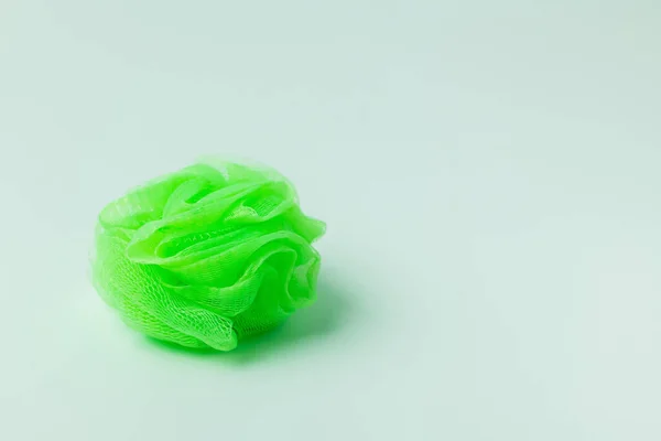 Bright green mesh washcloth on grey background — Stock Photo