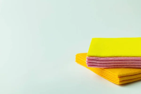 Stracci detergenti arancioni, gialli e rosa su sfondo grigio con spazio su copia — Foto stock