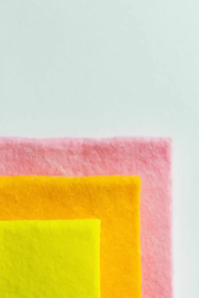 Close up of yellow, orange and pink rags isolated on grey, top view — стоковое фото