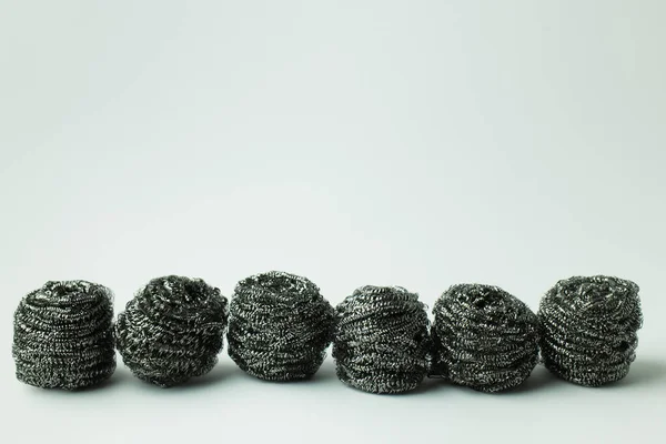 Row of abrasive metal scourers on grey background with copy space — Foto stock