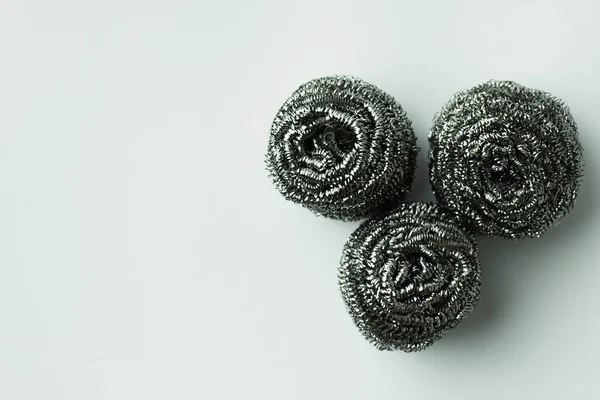 Top view of three stainless wire scourers on grey background — Stock Photo