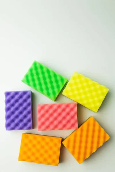 Top view of bright multicolored sponges on grey background — Photo de stock