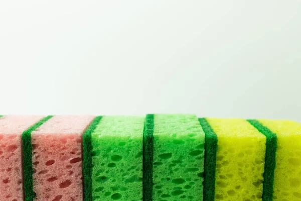Close up view of pink, green and yellow porous sponges isolated on grey - foto de stock
