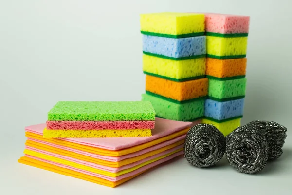 Bright sponge scourers, dishrags and metal scrubbers on grey background — Fotografia de Stock
