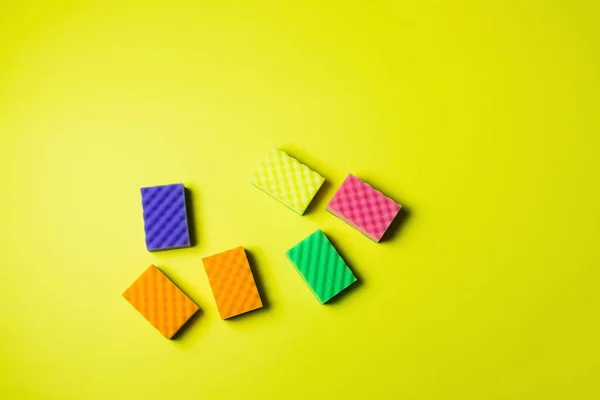 Top view of colorful sponges on bright yellow background with copy space — Stockfoto