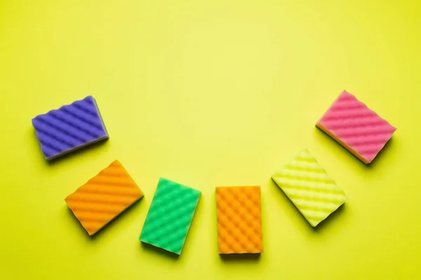 Vista superior de esponjas multicolores texturizadas sobre fondo amarillo - foto de stock