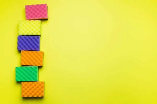 Top view of soft multicolored sponges on yellow background - foto de stock