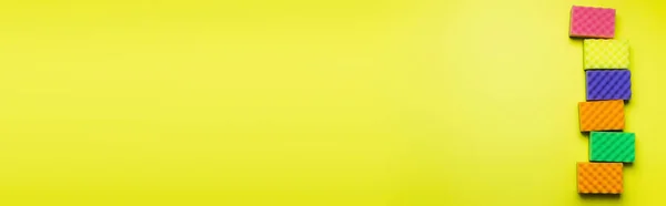 Vista superior de esponjas multicoloridas brilhantes no fundo amarelo com espaço de cópia, banner — Fotografia de Stock