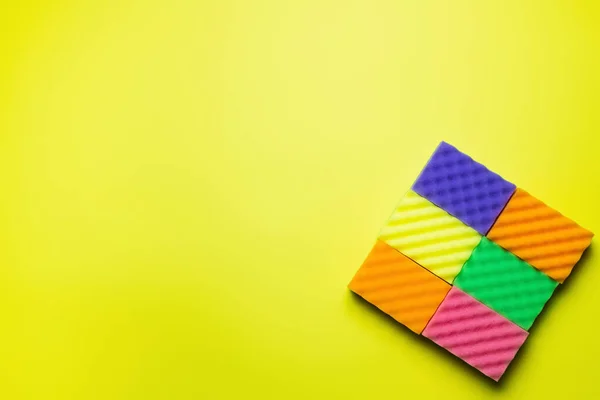 Top view of textured multicolored sponges on bright yellow background — Foto stock