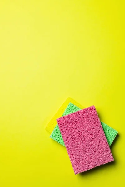 Top view of colorful and textured sponge cloths on yellow background - foto de stock