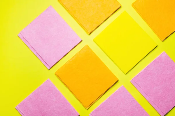 Top view of bright multicolored cleansing rags on yellow background — Stockfoto