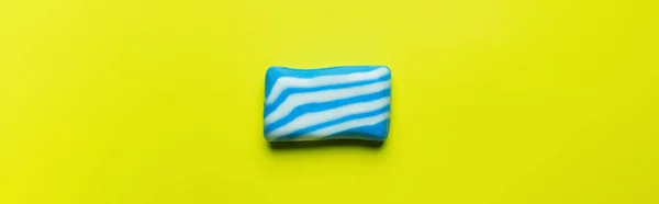 Vue du dessus du savon de bain avec des rayures blanches et bleues sur fond jaune, bannière — Photo de stock