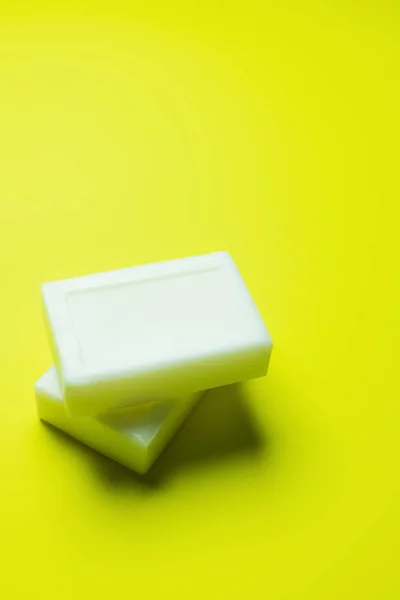 White soap bars on bright yellow background — Stock Photo