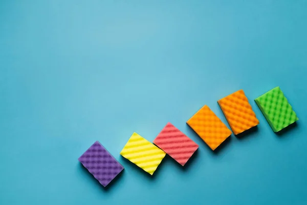 Top view of colorful sponges on blue background with copy space — Photo de stock