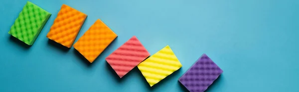 Top view of soft colorful sponges on blue background, banner — Stock Photo