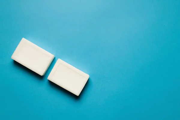 Top view of two toilet soap bars on blue background with copy space — стоковое фото