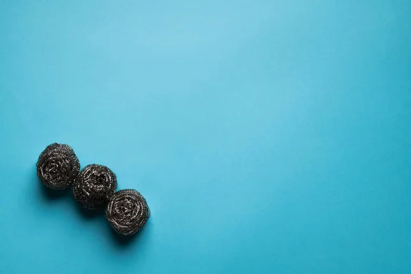 Top view of three metal wire scourers on blue background with copy space — Foto stock