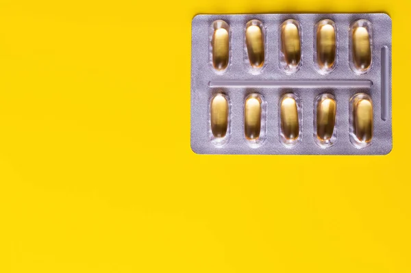 Vue du dessus de la plaquette thermoformée avec gélules isolées sur jaune — Photo de stock