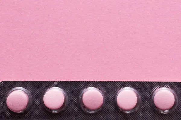 Vista de cerca del blister con pastillas aisladas en rosa - foto de stock