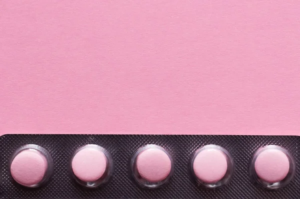 Vista de perto da embalagem blister com comprimidos isolados em rosa — Fotografia de Stock