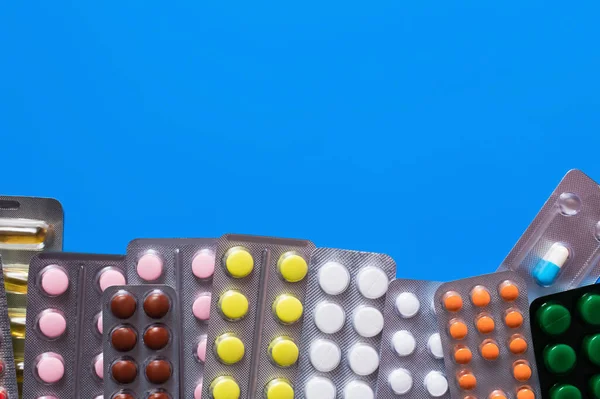 Top view of blister packs with different pills isolated on blue — Stock Photo