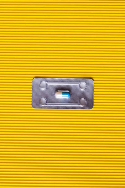 Vue du dessus de la plaquette thermoformée avec capsule antibiotique sur fond jaune texturé — Photo de stock