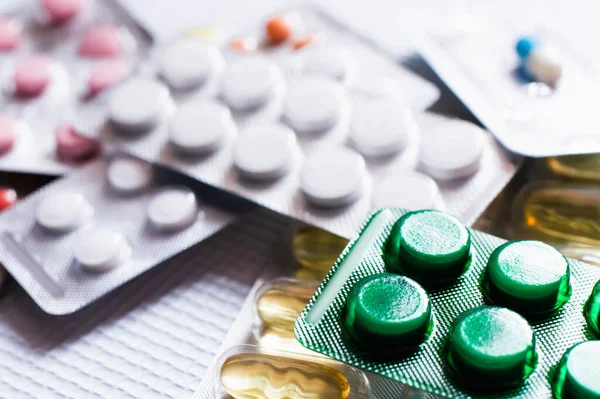 Close up of blister packs with different pills and capsules on textured white background — Photo de stock