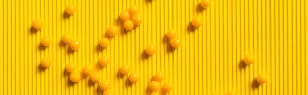 Top view of round shape medication on yellow textured background, banner — стоковое фото