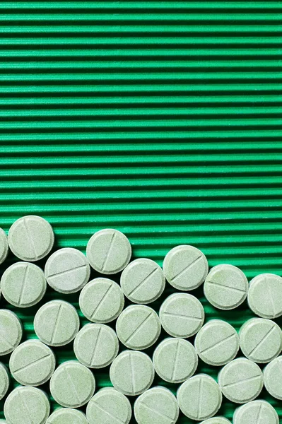 Vista superior de la medicación de forma redonda sobre fondo verde texturizado - foto de stock