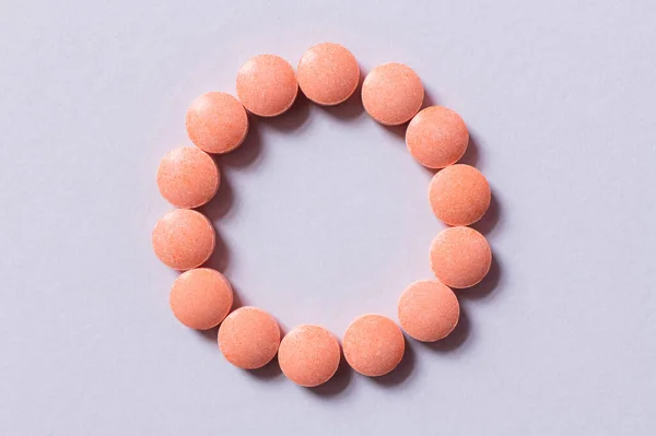 Vista dall'alto di pillole rosa a forma di cerchio su bianco — Foto stock