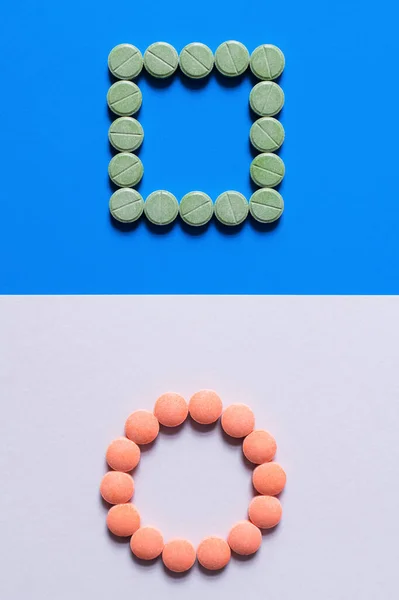 Vista dall'alto di pillole in forme di cerchio e quadrato su sfondo bianco e blu — Foto stock