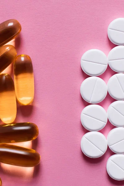 Top view of white round shape pills and jelly capsules on pink background — Fotografia de Stock