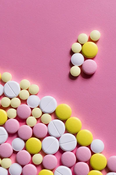 Piatto lay vista di diverse pillole di forma rotonda su sfondo rosa — Foto stock