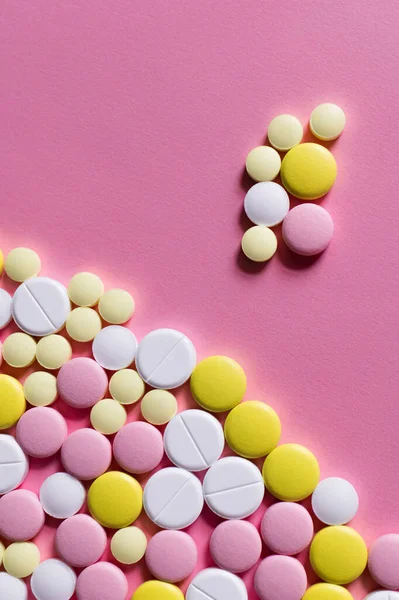 Flat lay view of different round shape pills on pink background — стоковое фото