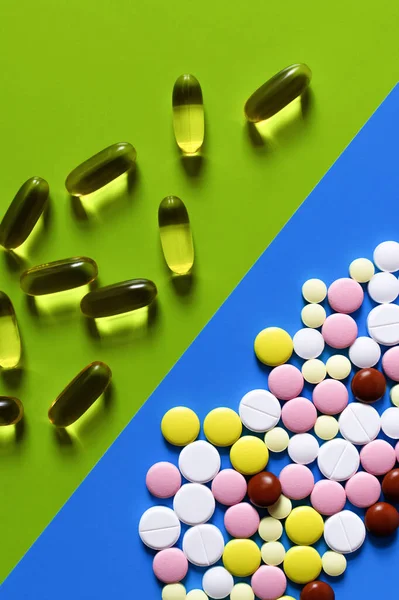 Top view of different colorful pills and jelly capsules on bright blue and green background - foto de stock