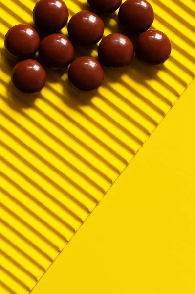 Close up vista da pilha com pílulas de forma redonda escura no fundo texturizado amarelo — Fotografia de Stock