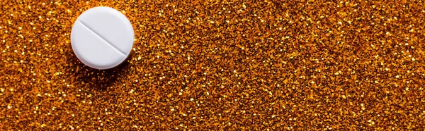 Top view of white pill on shiny brown gold background, banner — Stock Photo