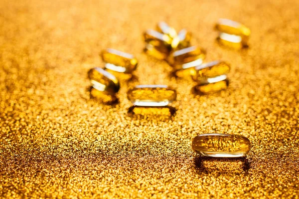 Close up view of jelly capsules on shiny golden background — стоковое фото