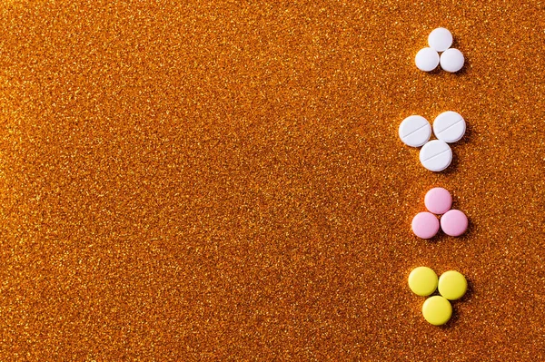 Vista superior da linha com diferentes pílulas coloridas no fundo brilhante — Fotografia de Stock