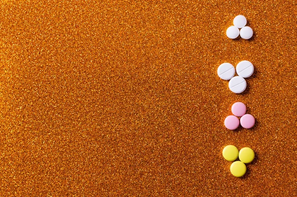 Top view of row with different colorful pills on shiny background — стоковое фото
