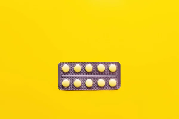 Top view of blister pack with medication isolated on yellow — Stock Photo