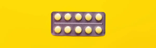 Vista dall'alto della confezione blister con farmaco isolato su giallo, banner — Foto stock