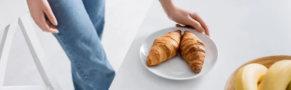 Cropped view of woman near plate with delicious croissants, banner — Foto stock