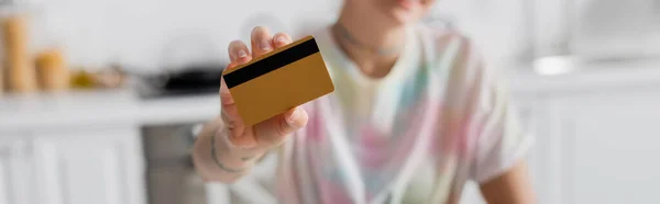 Selective focus of credit card in hand of cropped woman on blurred background, banner — Foto stock