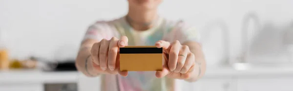 Selective focus of credit card in hands of cropped woman on blurred background, banner — Stockfoto