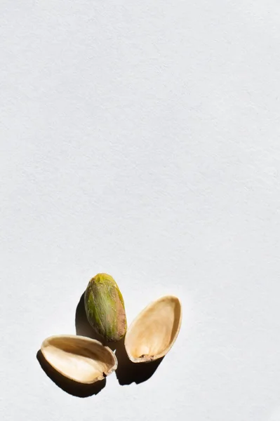 Top view of cracked organic and salty pistachio near shells on white background - foto de stock